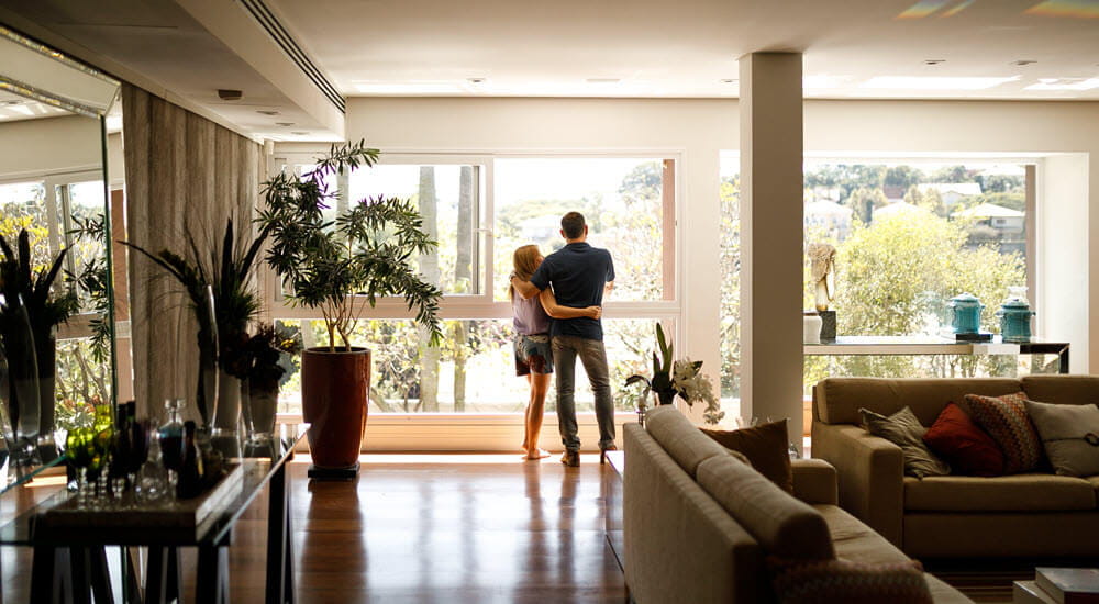 LMI - homepage - Couple admiring the view from the living room of their house